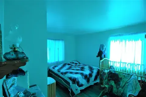 What appears to be a child’s bedroom. Everything is seafoam green. The walls, the curtains, the ceiling. You know a child suffers here.